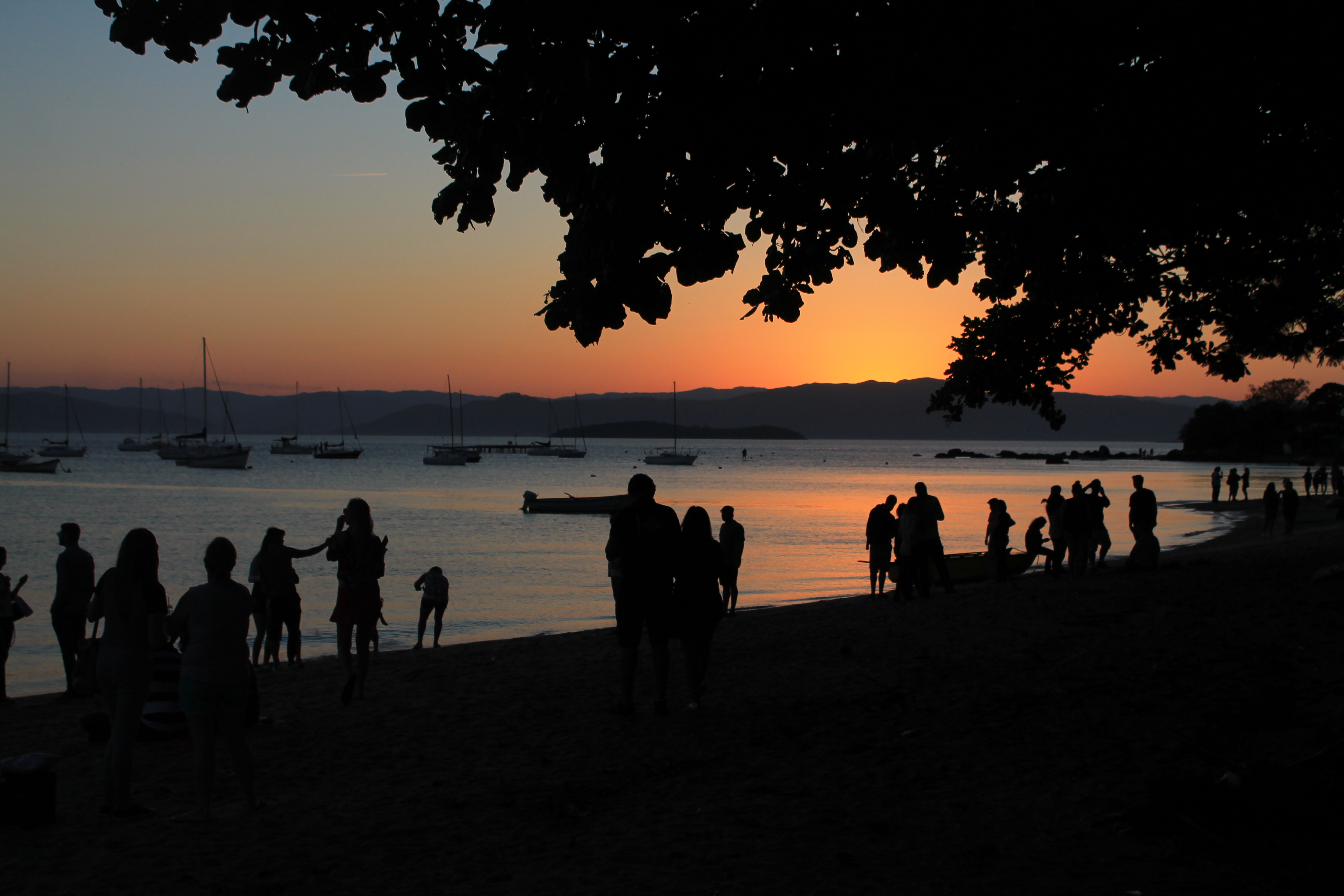 Pôr do sol em Santo Antônio de Lisboa com barcos e reflexo dourado no mar